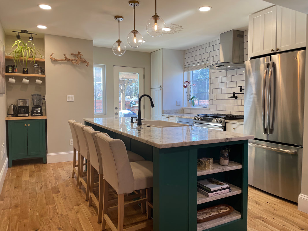Renovated modern kitchen with green island and brass pendant lighting